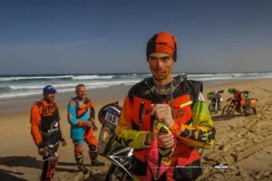 Portrait d'un pilote de moto après l'arrivée du rallye Africa Eco Race sur la plage.