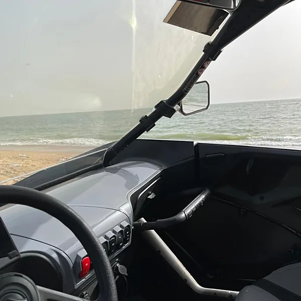 Volant et tableau de bord du buggy, vue sur l'océan près de Saly