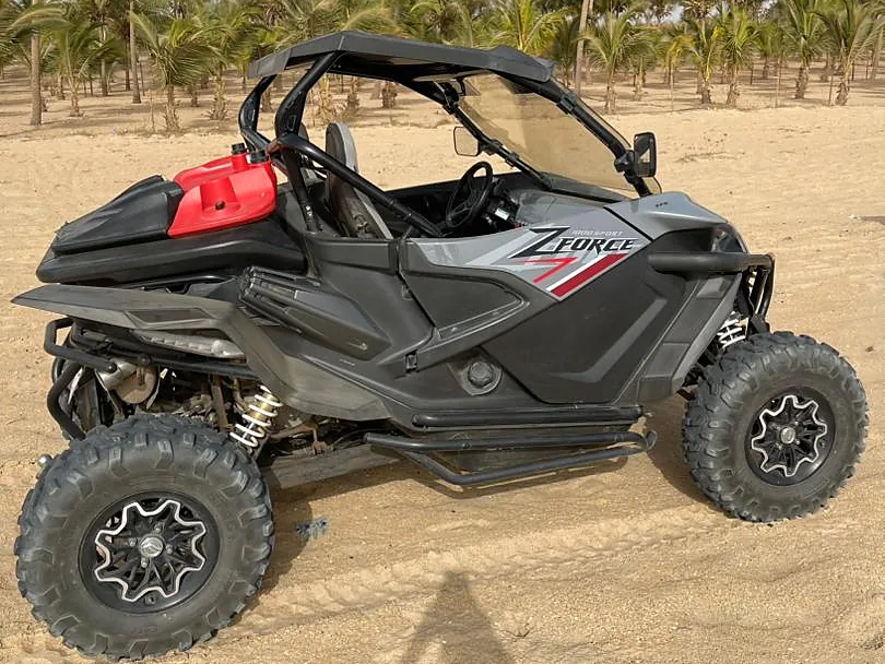 Buggy biplace ZForce garé sur une plage bordée de palmiers près de Saly